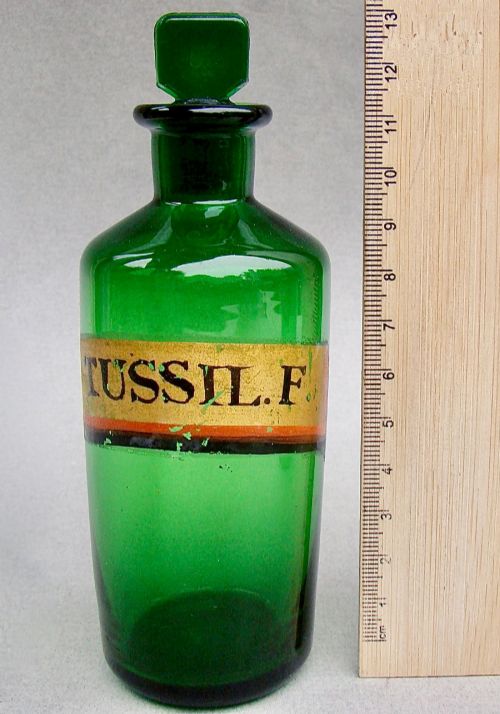 fig 2. A pair of late Victorian cylindrical Bristol green glass apothecary bottles with ground stoppers and gilt-painted labels.