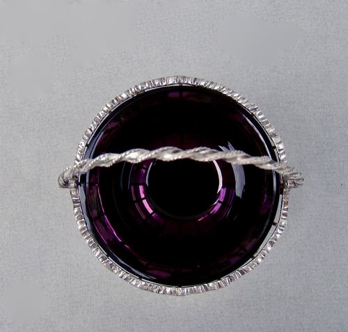 fig 2. A sterling silver wirework sugar basket featuring a twisted swing handle, cast vine leaf motifs, and a removable purple glass liner.