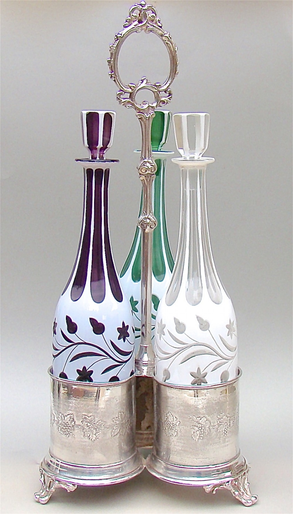 SET OF THREE 19TH C. BOHEMIAN GLASS DECANTERS WITH SILVER PLATED STAND, CIRCA 1890