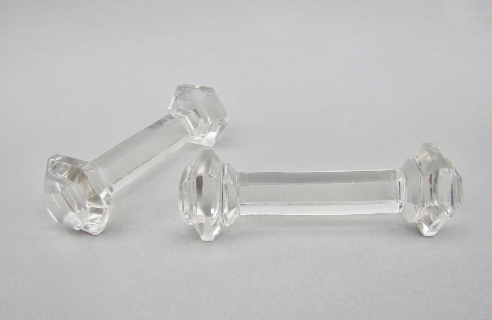 A pair of clear Victorian cut crystal glass knife rests featuring faceted octagonal ends and a central connecting bar. View II