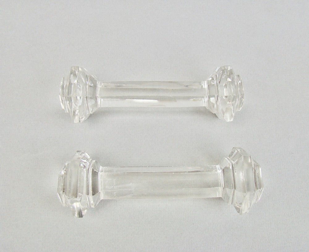 A pair of clear Victorian cut crystal glass knife rests featuring faceted octagonal ends and a central connecting bar. View IV