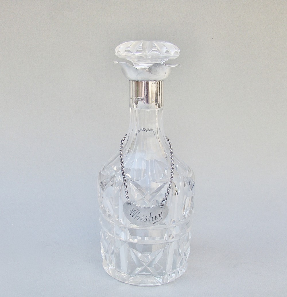 SMALL ART DECO SILVER MOUNTED GLASS DECANTER, BIRMINGHAM 1928 WITH EDWARDIAN SILVER WHISKY LABEL, LONDON 1904
