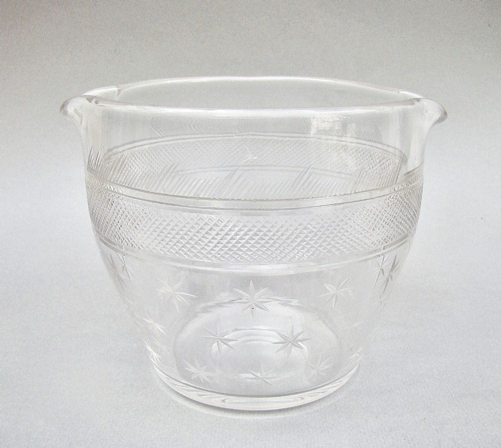 A clear late 18th-century Georgian glass rinser featuring twin pouring spouts, a diamond-cut waistband, and starburst motifs etched around the lower bowl.