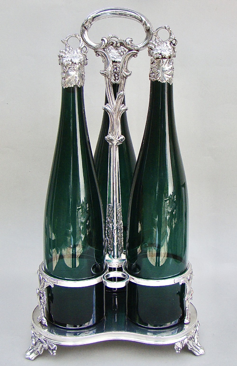 SET OF THREE VICTORIAN BRISTOL GREEN GLASS DECANTER BY HENRY WILKINSON & CO, BIRMINGHAM 1839 IN THEIR ORIGINAL SILVER PLATED STAND