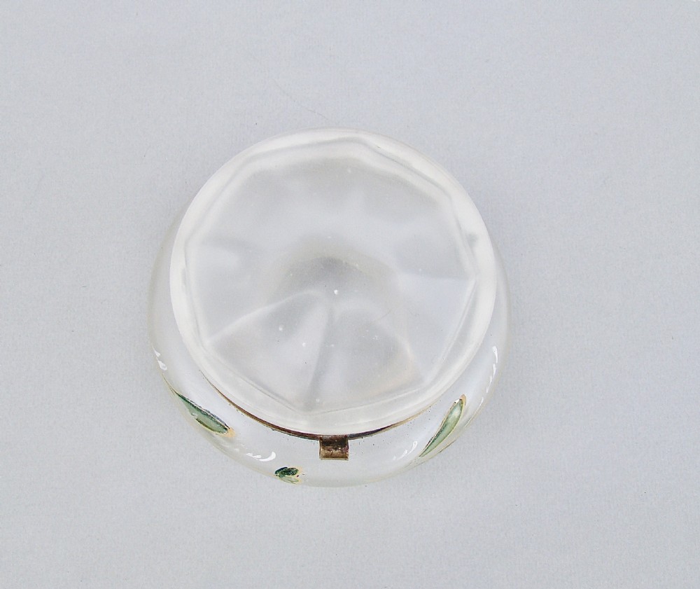 A rounded frosted glass trinket box featuring painted green leaf motifs, a brass hinged rim, and four scroll-form brass feet. View V
