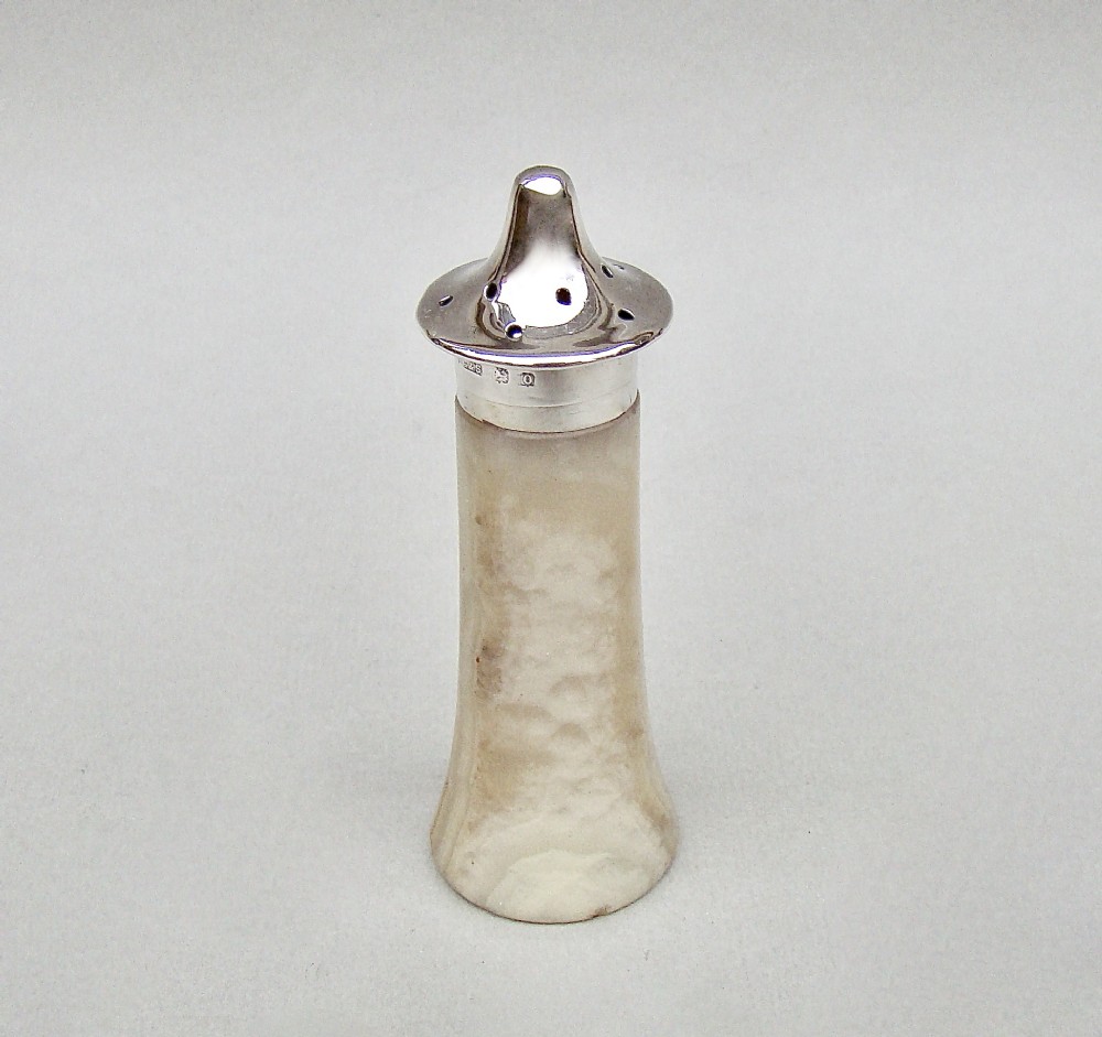 An Edwardian silver-mounted agate pepper pot featuring a carved stone base with a hallmark-stamped sterling silver collar and perforated cap.