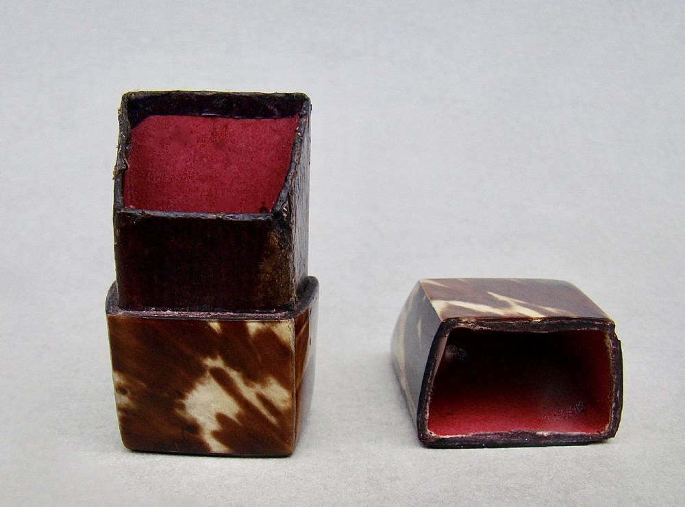 An early Victorian tortoiseshell needle box with a slanted top and mottled brown and cream pattern. View V
