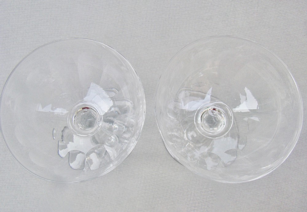 Pair of clear Victorian glass champagne coupes featuring slice-cut bowls and faceted stems on circular feet. View IV