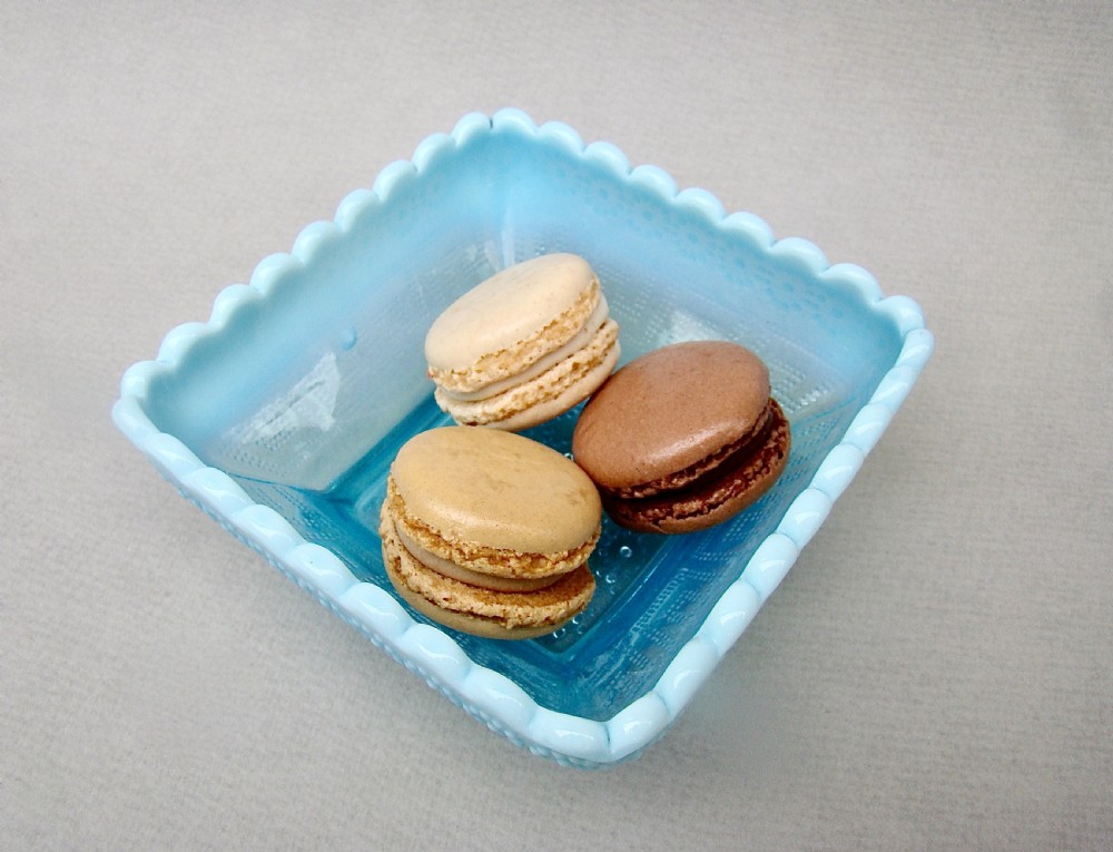A square blue opalescent pressed glass bowl featuring a scalloped rim and moulded daisy pattern on a footed base. View VI