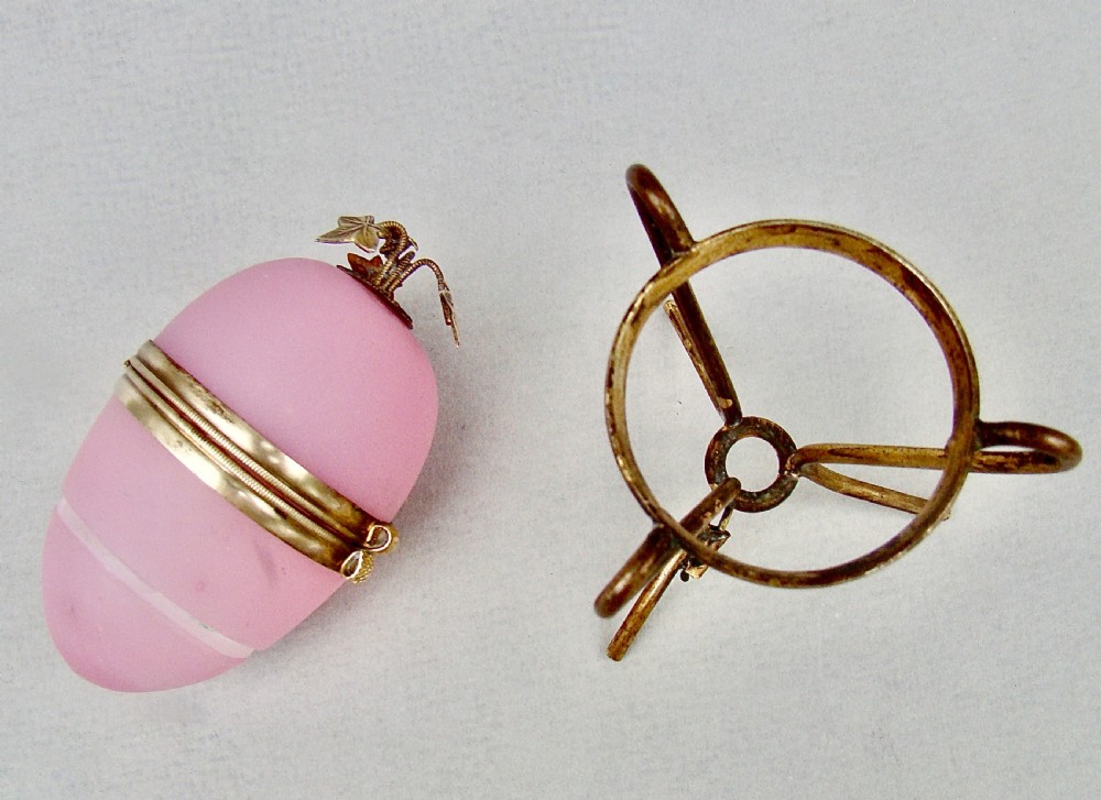 A pink opaline glass egg-shaped casket with hinged gilt metal mounts resting on an ormolu tripod stand. View V