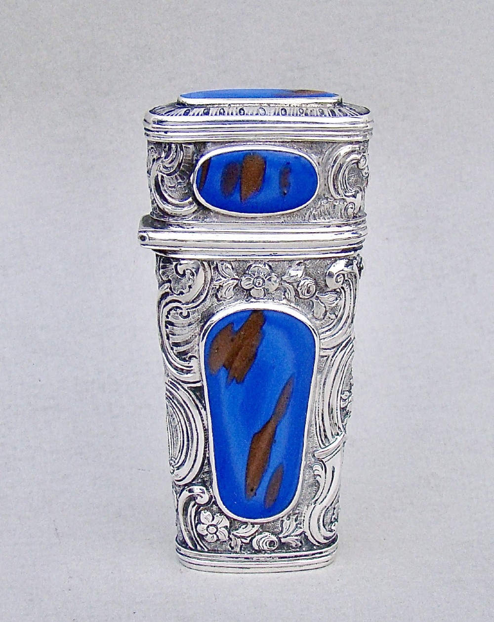 An 18th-century French silver travelling etui featuring ornate repousse scrollwork and inlaid blue aventurine panels.
