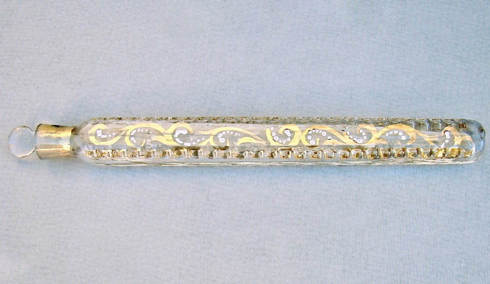 An elongated clear glass Oxford lavender scent bottle with hand-painted gold leaf scrollwork, white enamel accents, and a glass stopper. View II