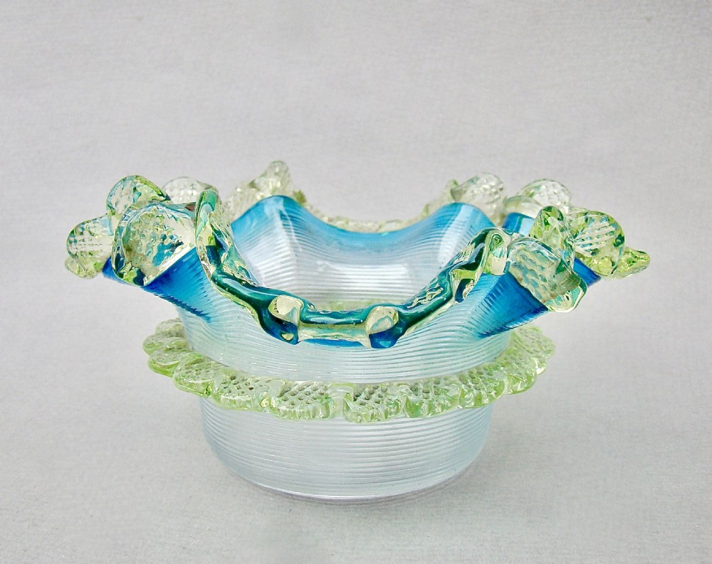 A Victorian threaded art glass sweetmeat dish featuring a turquoise body and an applied yellow-green uranium glass rim. View IV
