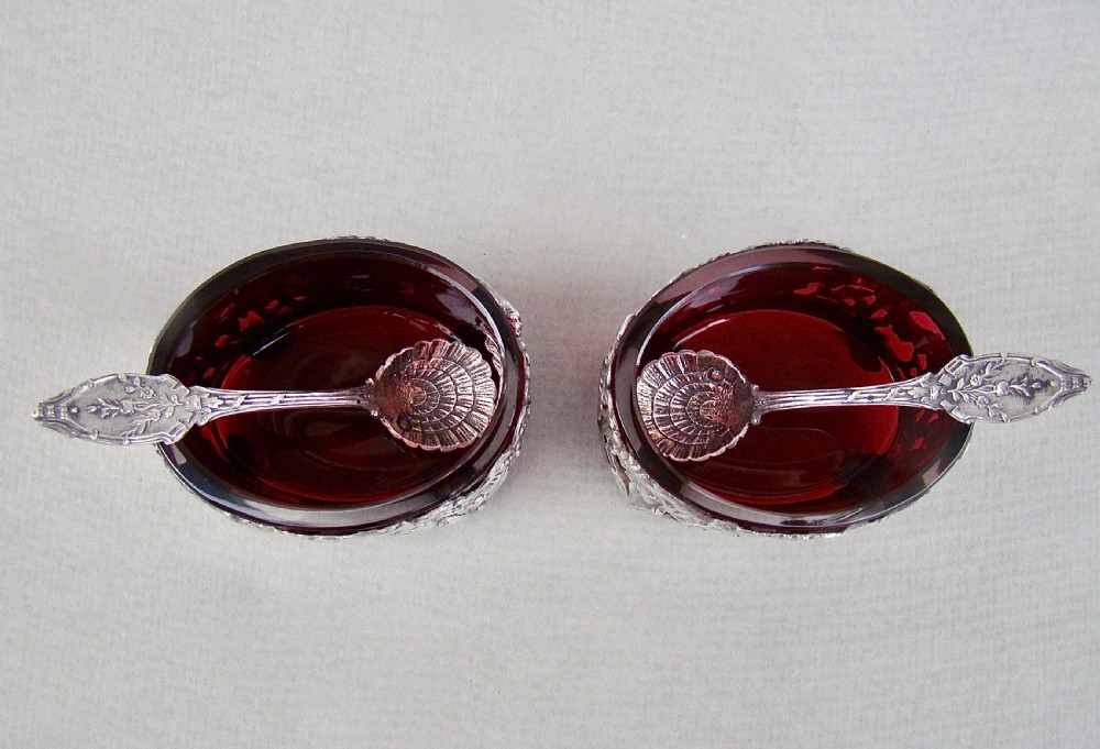 A pair of 19th-century French silver salt cellars with pierced rococo scrollwork frames, ruby glass liners, and matching silver salt spoons. View III
