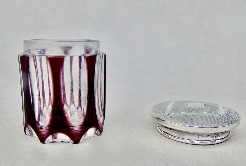An Art Deco faceted amethyst glass rouge pot featuring an engine-turned sterling silver lid with geometric diamond engraving. View V