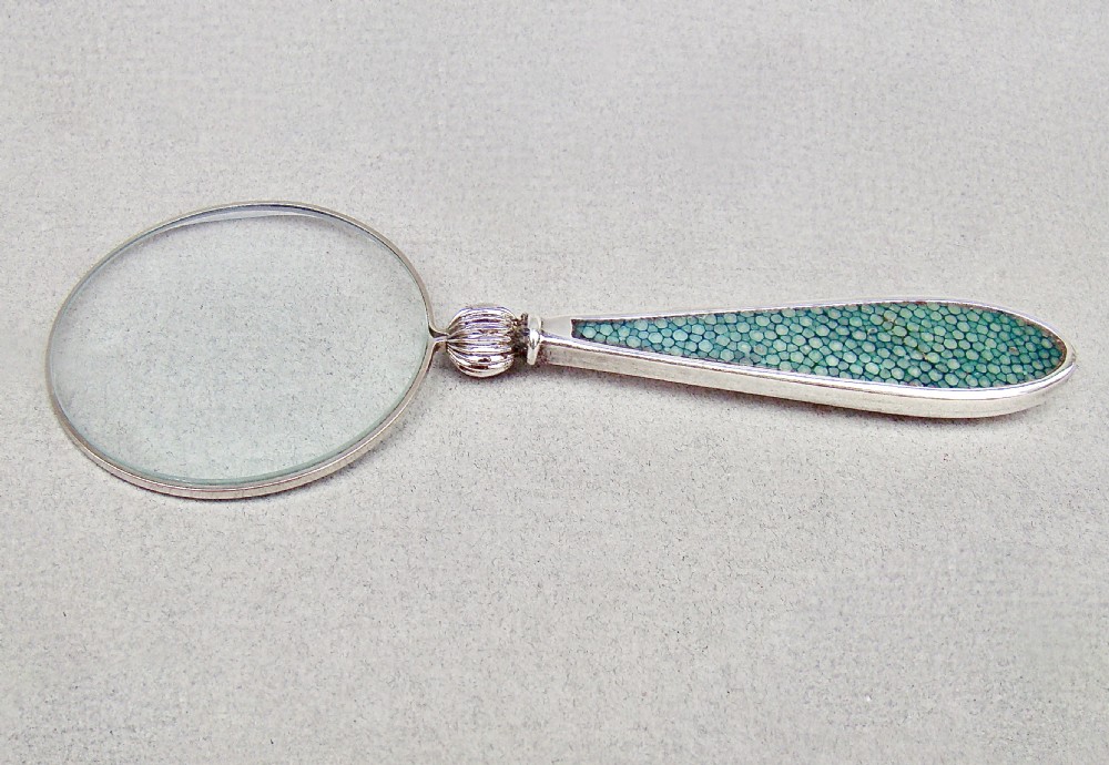 An Art Deco silver magnifying glass featuring a circular glass lens and a tapered handle inlaid with green shagreen. View II