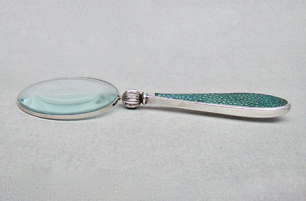 An Art Deco silver magnifying glass featuring a circular glass lens and a tapered handle inlaid with green shagreen. View V