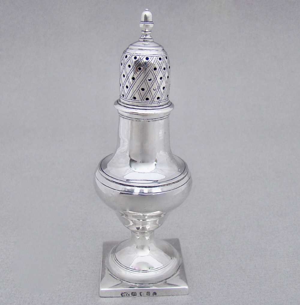 A Georgian sterling silver sugar caster featuring a baluster-shaped body, square base, and a pierced lattice lid topped with a finial.