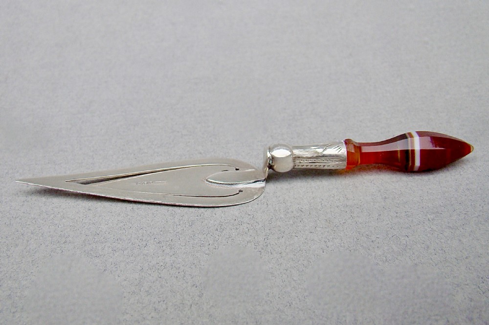 An Edwardian sterling silver trowel-shaped bookmark featuring an engraved ferrule and a pointed, banded agate handle. View II