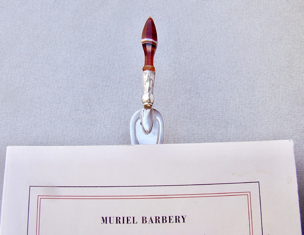 An Edwardian sterling silver trowel-shaped bookmark featuring an engraved ferrule and a pointed, banded agate handle. View VII