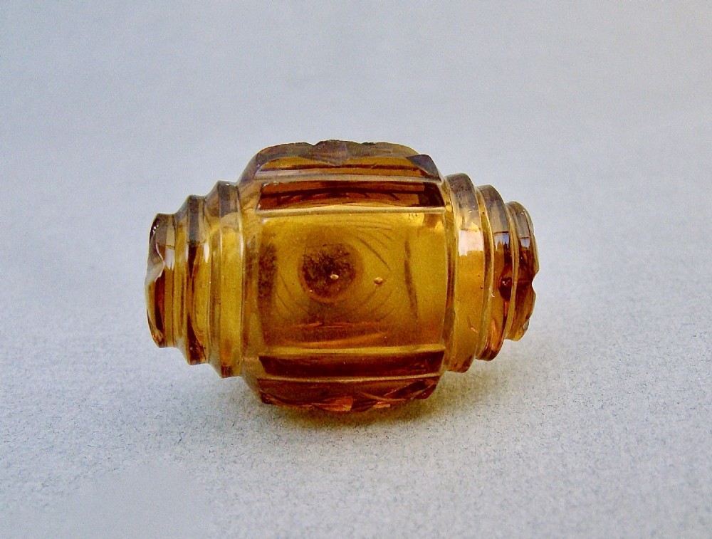A late Victorian amber glass scent bottle featuring a faceted cut glass body and an embossed silver cap. View VI