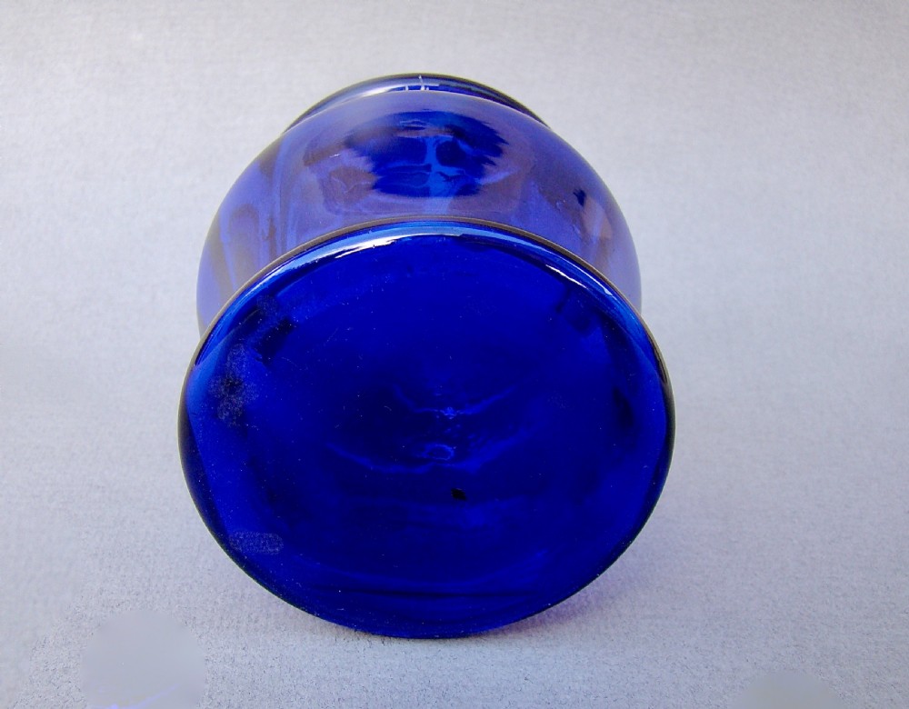 A deep cobalt blue glass dressing table jar featuring hand-painted white daisy enamel decoration and a hinged metal rim. View VI
