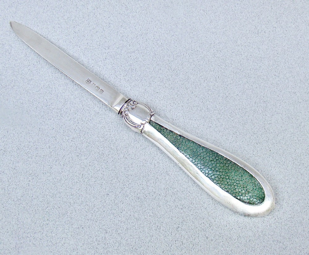 An Art Deco sterling silver letter opener featuring a green shagreen inlay on the handle and British silver hallmarks on the blade.