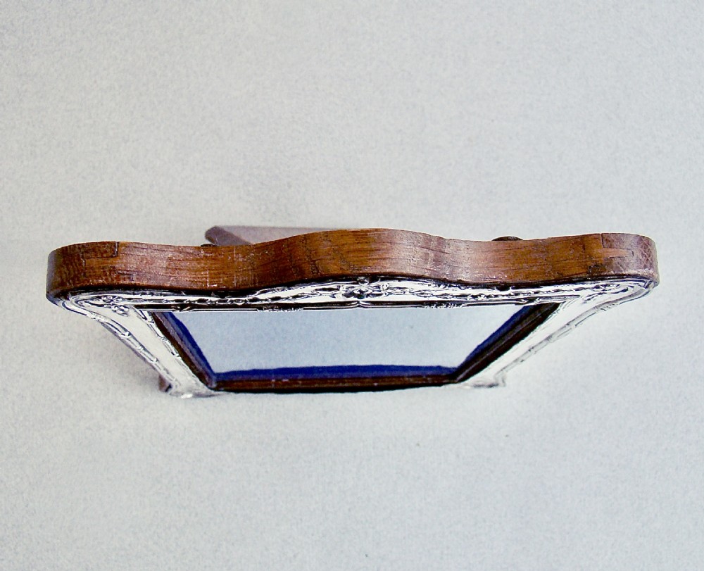 An antique sterling silver photo frame featuring an ornate crest with a ribbon bow motif and a shaped top edge. View IV