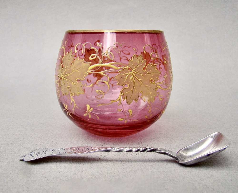 A round Moser cranberry glass open salt cellar decorated with hand-applied gold leaf vines and an engraved French silver spoon inside. View IV