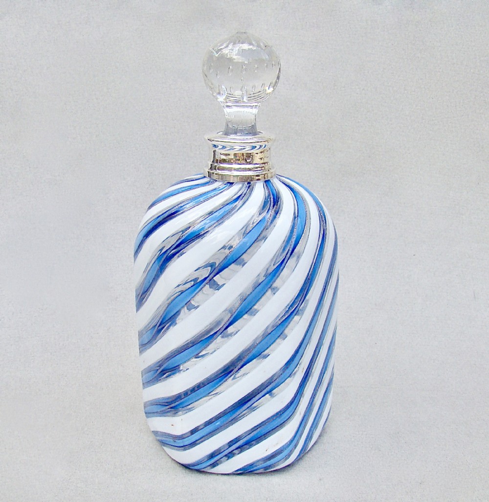 An Edwardian swirl-patterned blue and white latticino glass decanter featuring a hallmarked silver collar and a clear glass stopper.