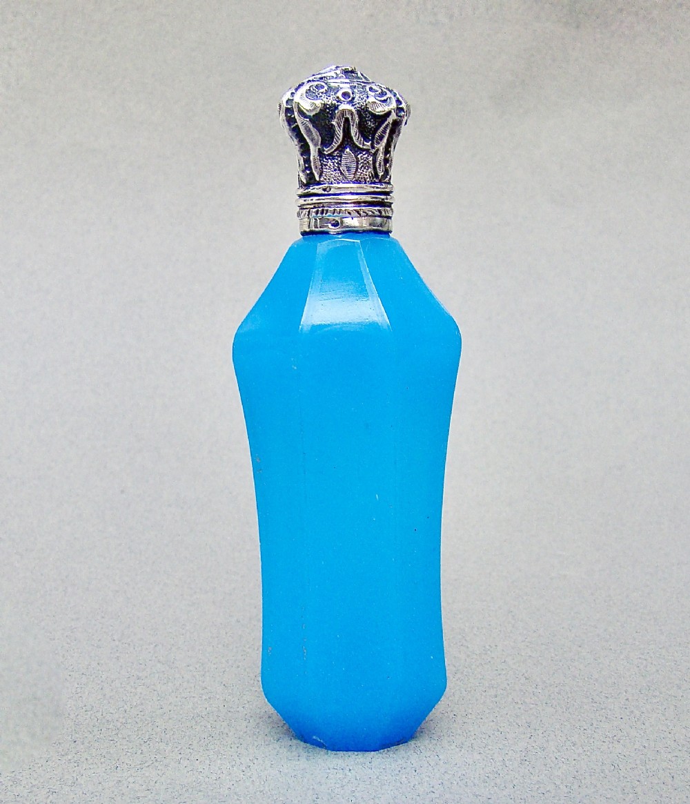A faceted turquoise blue opaline glass scent bottle featuring an embossed silver neck and cap.