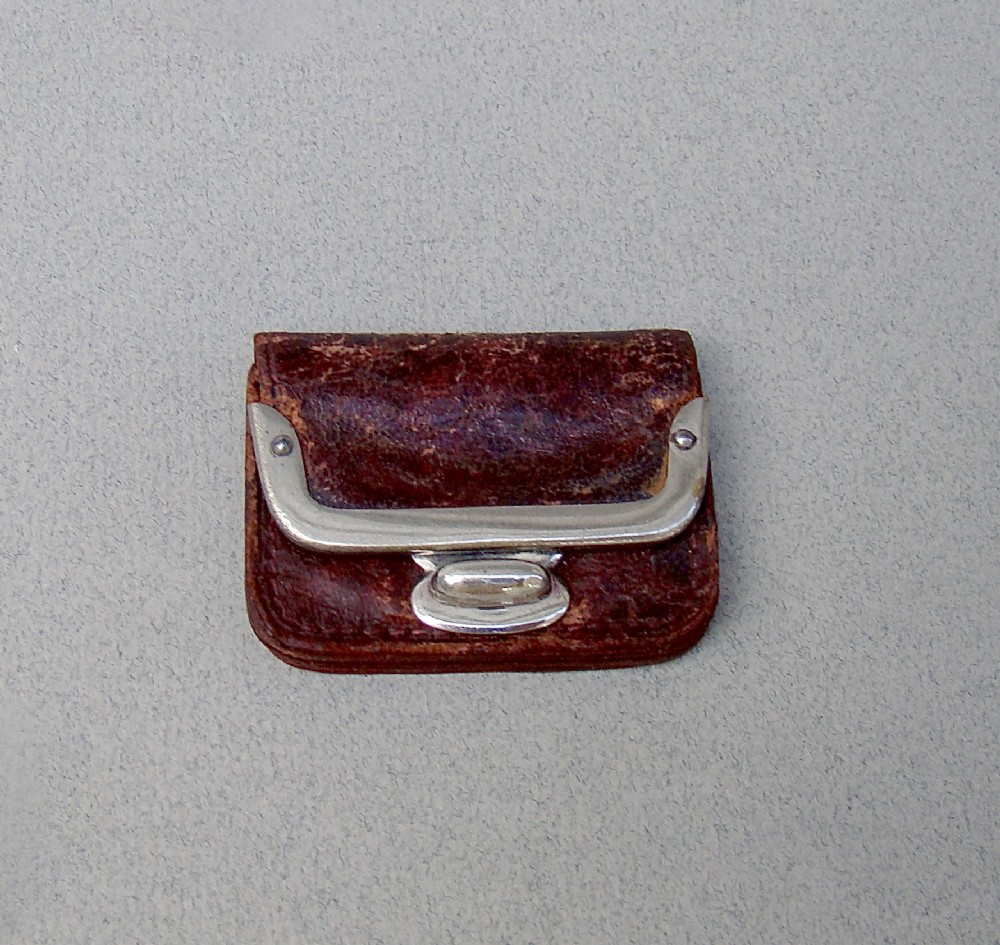 A miniature dark brown leather sovereign purse featuring a silver-plated hinged metal catch.