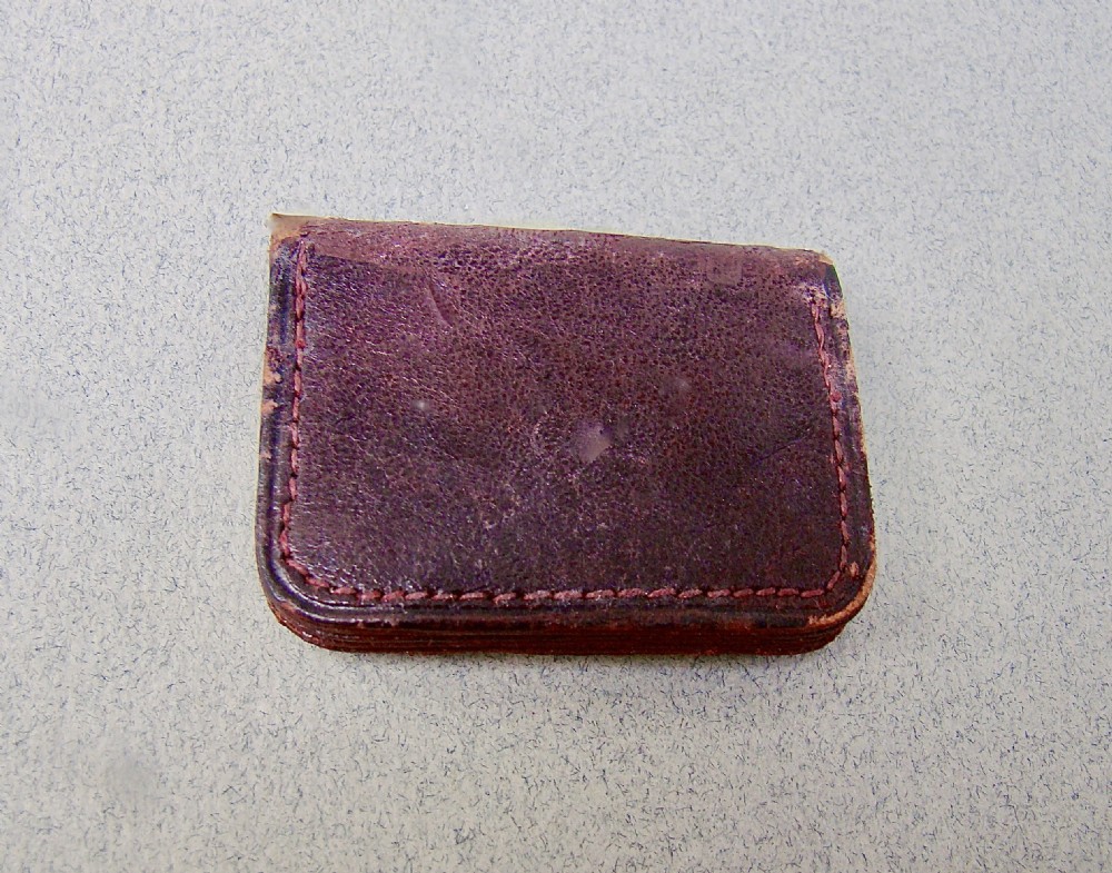 A miniature dark brown leather sovereign purse featuring a silver-plated hinged metal catch. View III