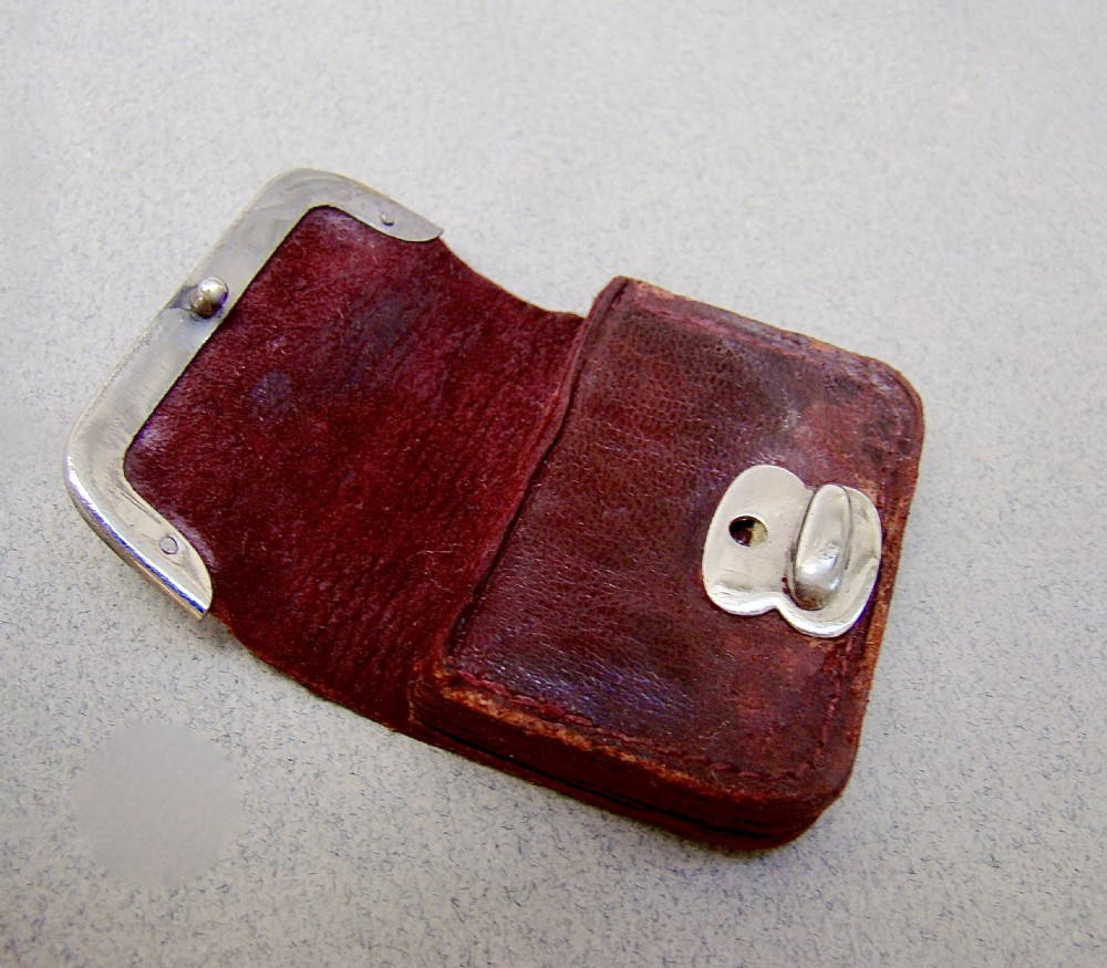A miniature dark brown leather sovereign purse featuring a silver-plated hinged metal catch. View IV