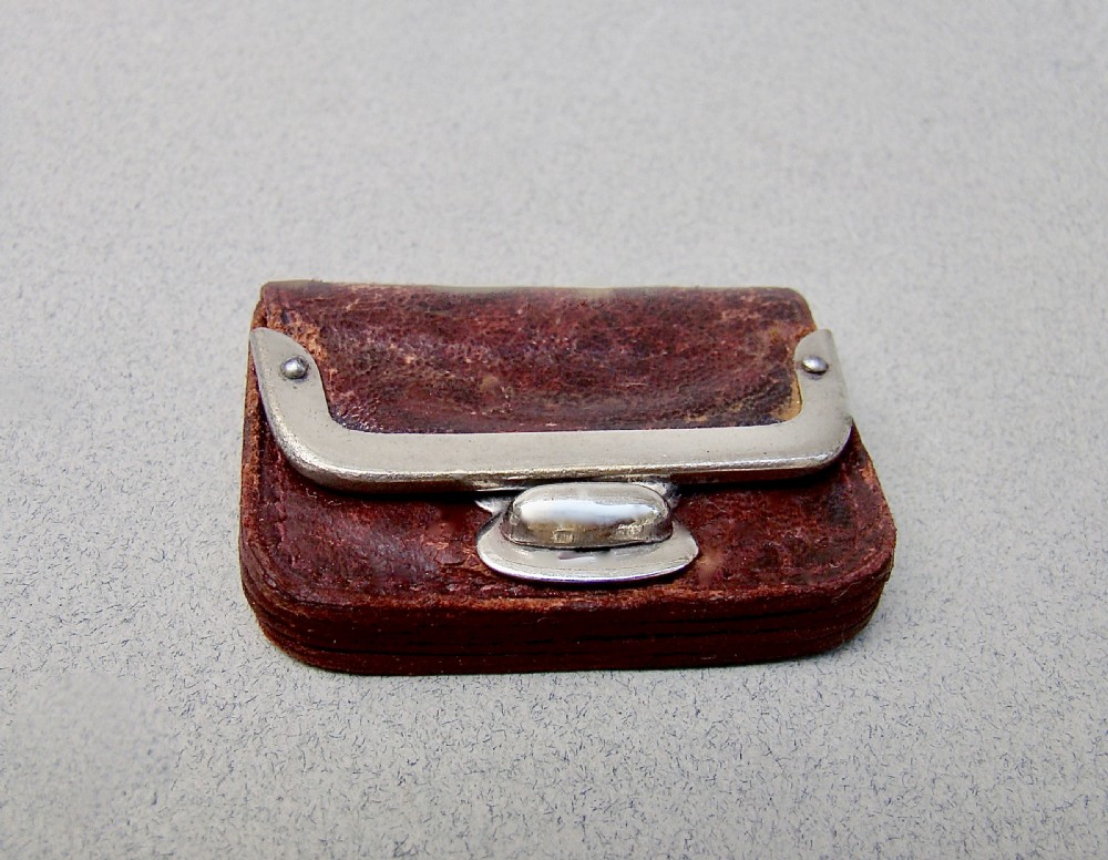 A miniature dark brown leather sovereign purse featuring a silver-plated hinged metal catch. View V