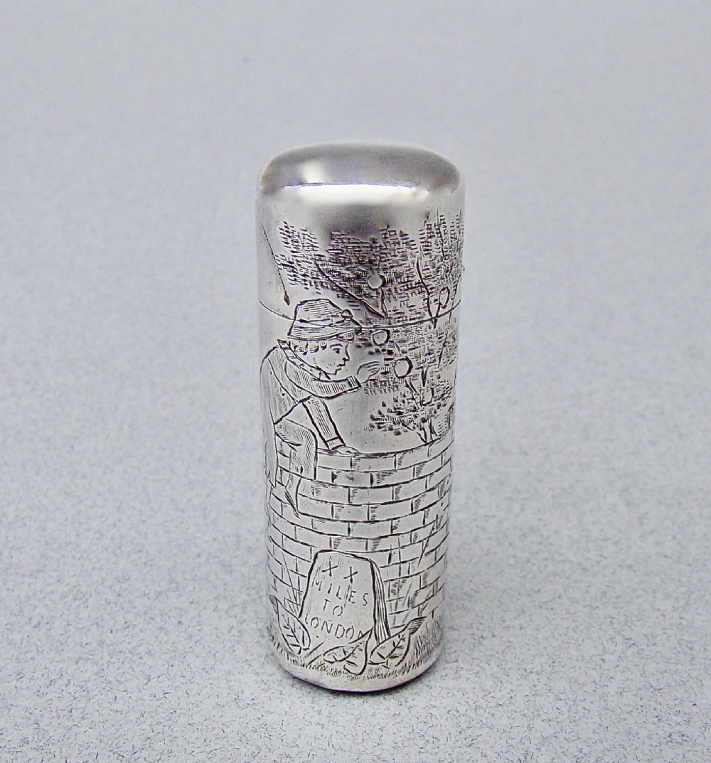 A cylindrical Victorian sterling silver scent bottle decorated with an engraved illustration of a child on a brick wall near a milestone.