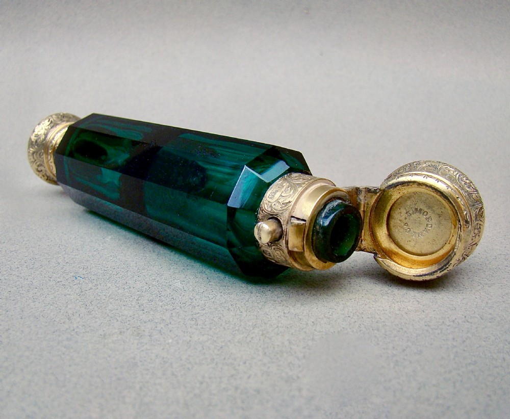 A Victorian double-ended faceted Bristol green glass scent bottle featuring intricately engraved silver-gilt caps on both ends. View III