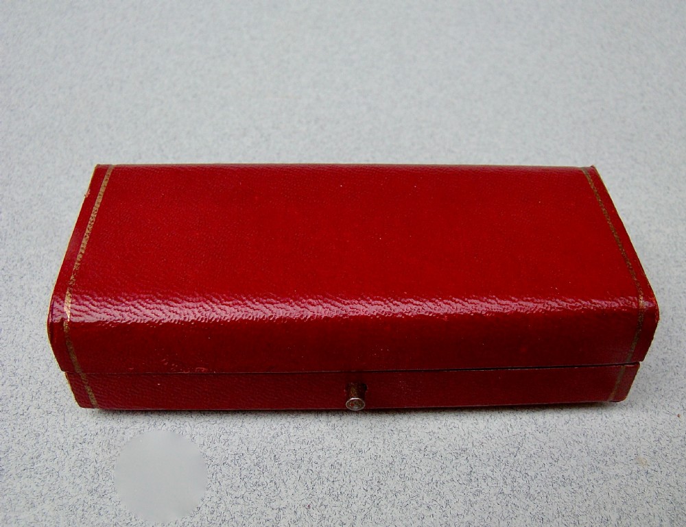 A Victorian sterling silver trowel-shaped bookmark with an agate handle inside a red leather Harrods case. View VI