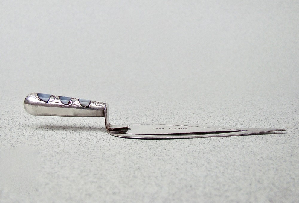 A Victorian sterling silver trowel-shaped bookmark with an agate handle inside a red leather Harrods case. View IX
