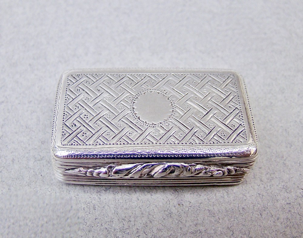 A small rectangular Georgian sterling silver box featuring intricate lattice hand engraving, a central circular cartouche, and reeded sides.