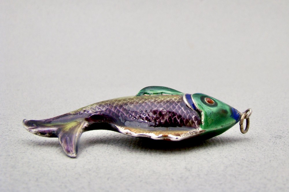 A silver fish-shaped pendant featuring green and purple guilloche enamel across the body and a suspension loop at the mouth. View III