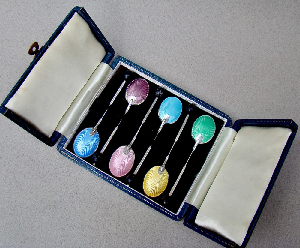 A cased set of six sterling silver coffee spoons featuring bean knops and engine-turned guilloche enamel bowls in various pastel colours. View IX