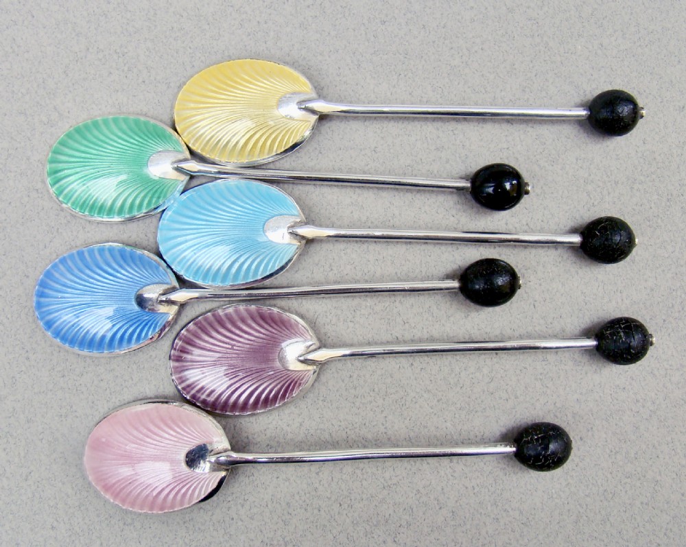 A cased set of six sterling silver coffee spoons featuring bean knops and engine-turned guilloche enamel bowls in various pastel colours. View IV