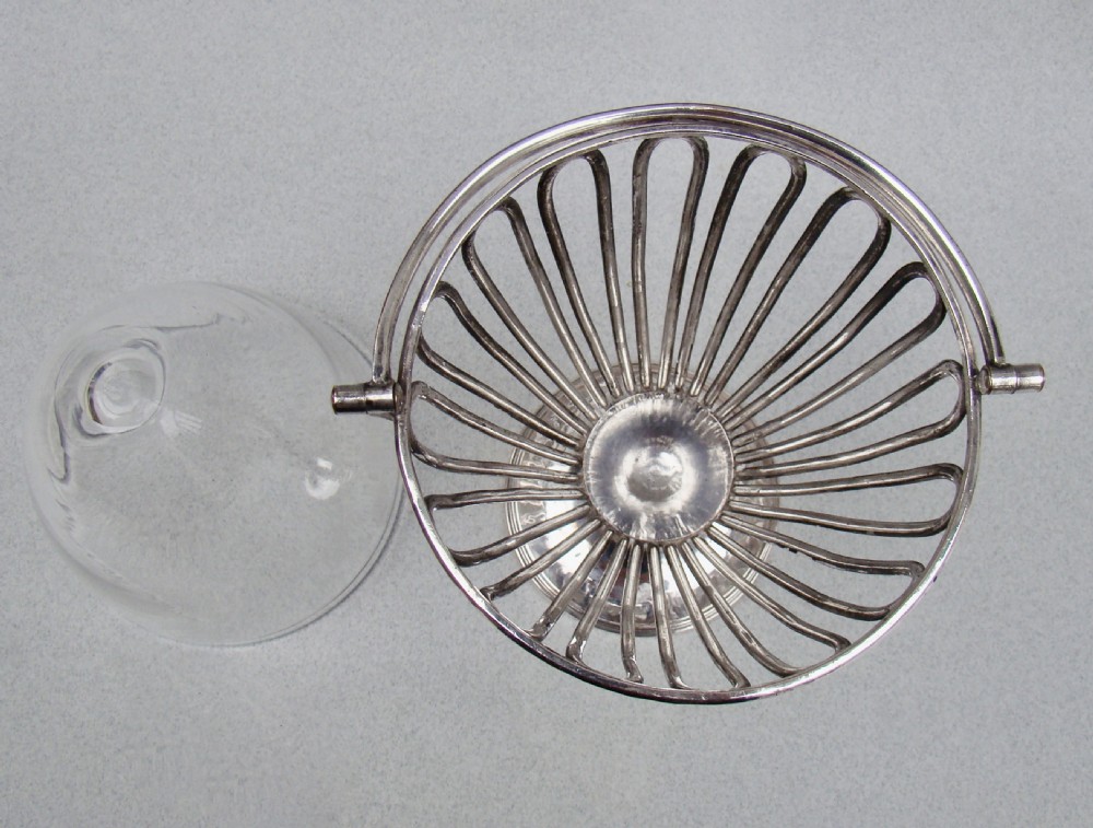 A Georgian Old Sheffield Plate wirework sugar vase featuring an arched swing handle, loop-pattern wire body, and a turned pedestal base. View V
