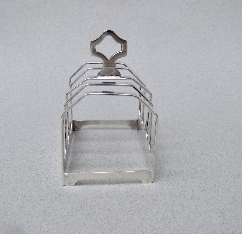 An Art Deco solid silver four-slice toast rack featuring angular dividers and a geometric central handle. View III