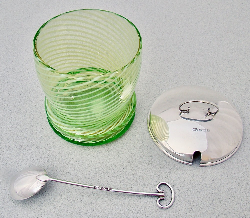 A green spiral-patterned vaseline glass preserve pot with a polished hallmarked silver lid and matching silver spoon. View IV