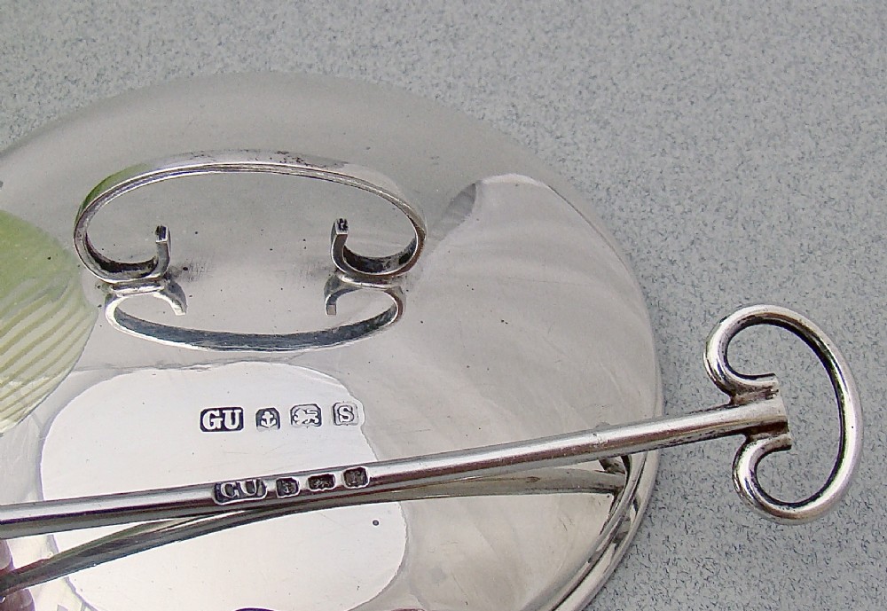 A green spiral-patterned vaseline glass preserve pot with a polished hallmarked silver lid and matching silver spoon. View V