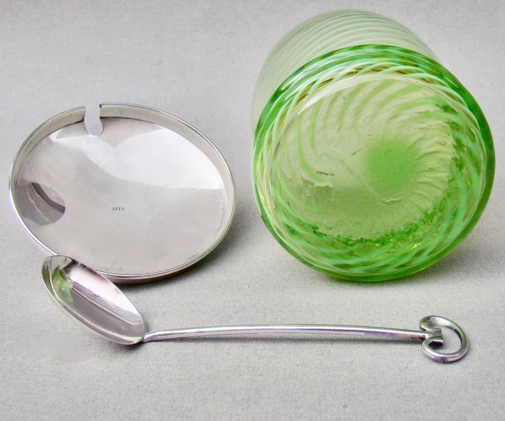 A green spiral-patterned vaseline glass preserve pot with a polished hallmarked silver lid and matching silver spoon. View VI