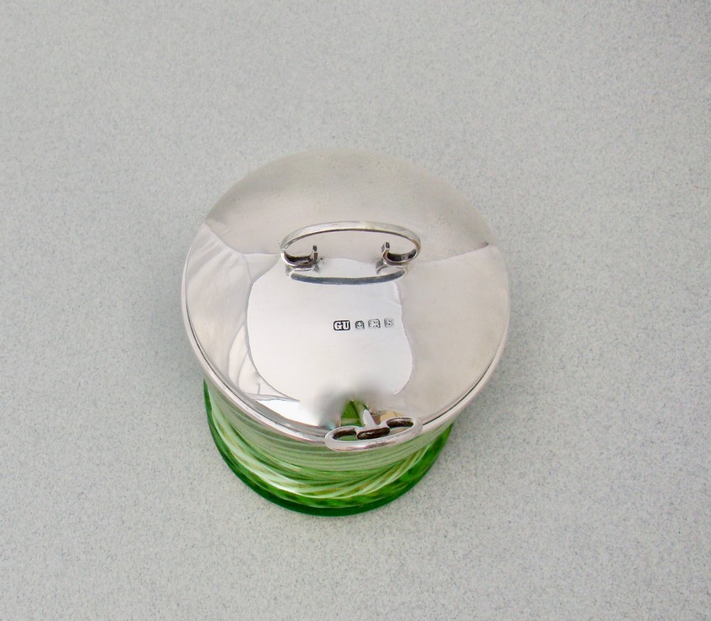 A green spiral-patterned vaseline glass preserve pot with a polished hallmarked silver lid and matching silver spoon. View VII
