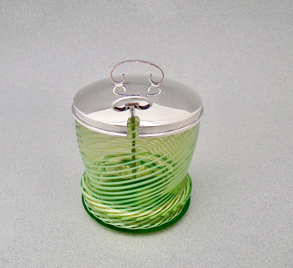 A green spiral-patterned vaseline glass preserve pot with a polished hallmarked silver lid and matching silver spoon. View VIII